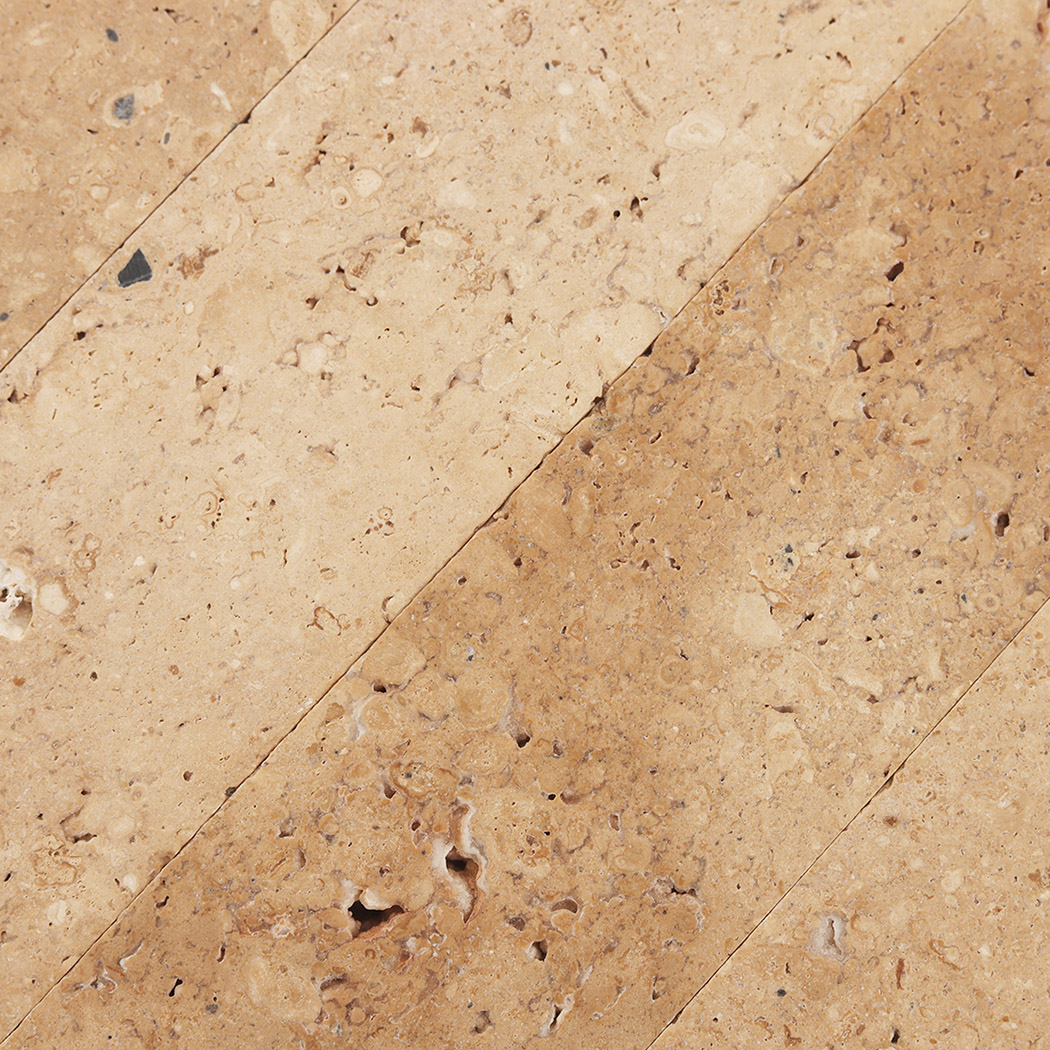 Close up of beige limestone tile surface with fossils and warm stone tones