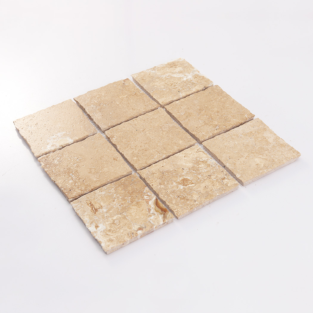 Angled display of beige square limestone mosaic tiles with natural warm tones