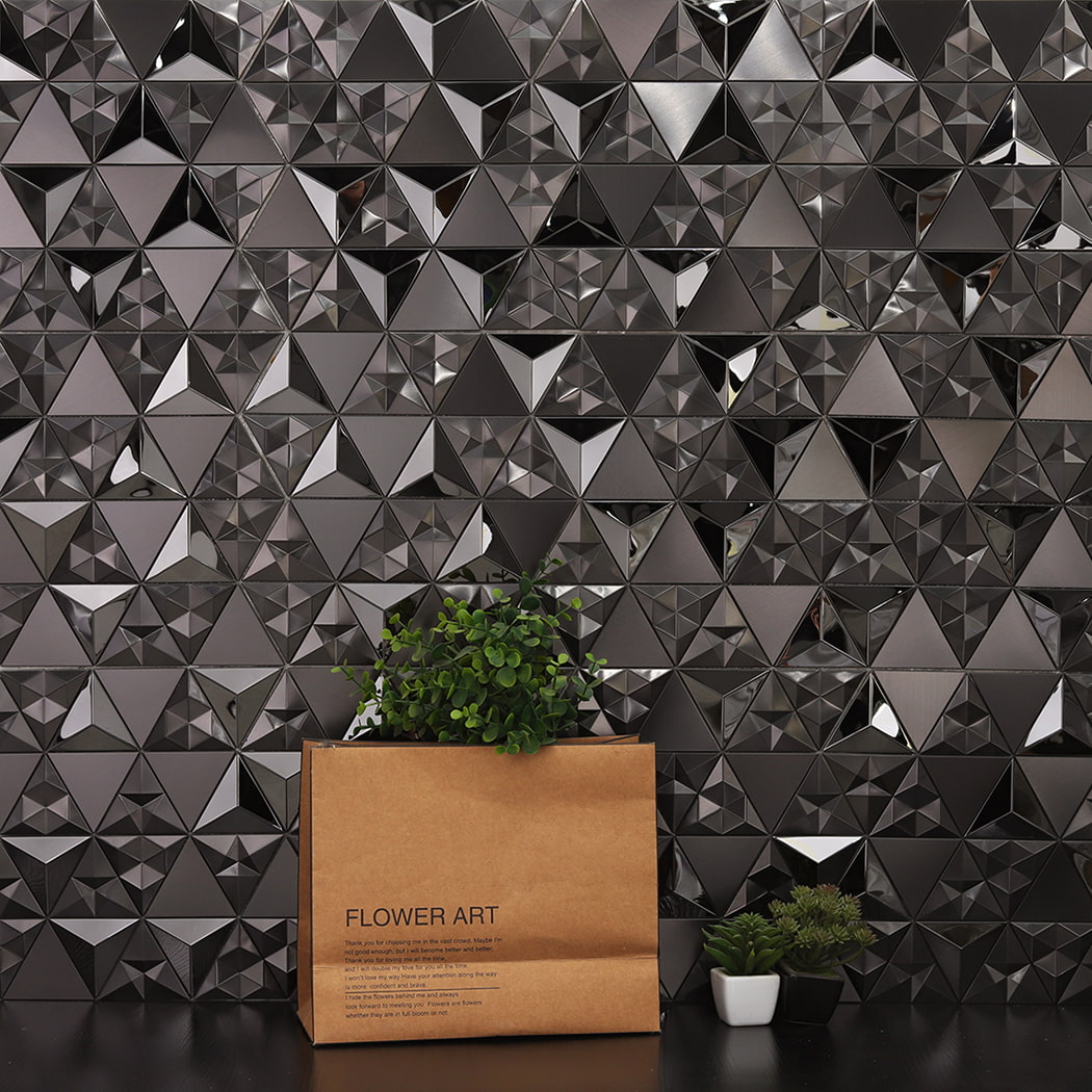 Modern black 3D triangle mosaic wall background with a paper bag and plants in front.