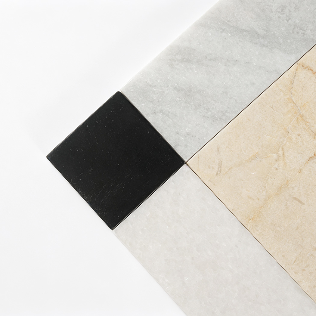 Close view of black corner accent with white and beige marble floor tile