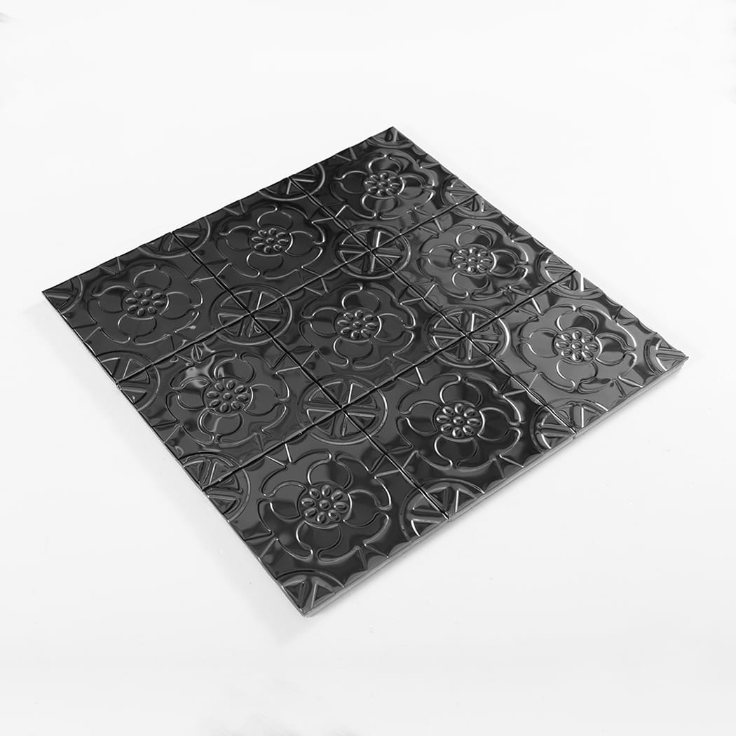 Angled display photo of a black embossed floral metal mosaic tile sheet.