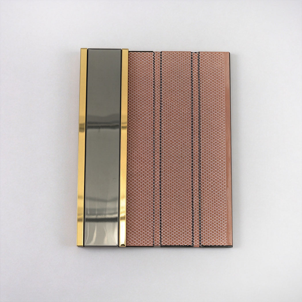 Back view showing mesh backing on a black and gold vertical stacked tile