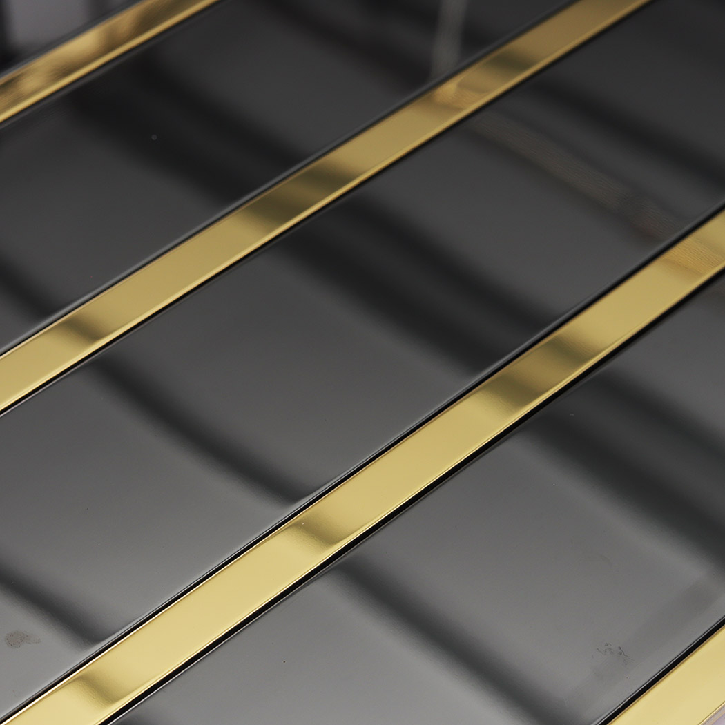 Close-up of glossy black vertical stacked tiles with gold metal strips