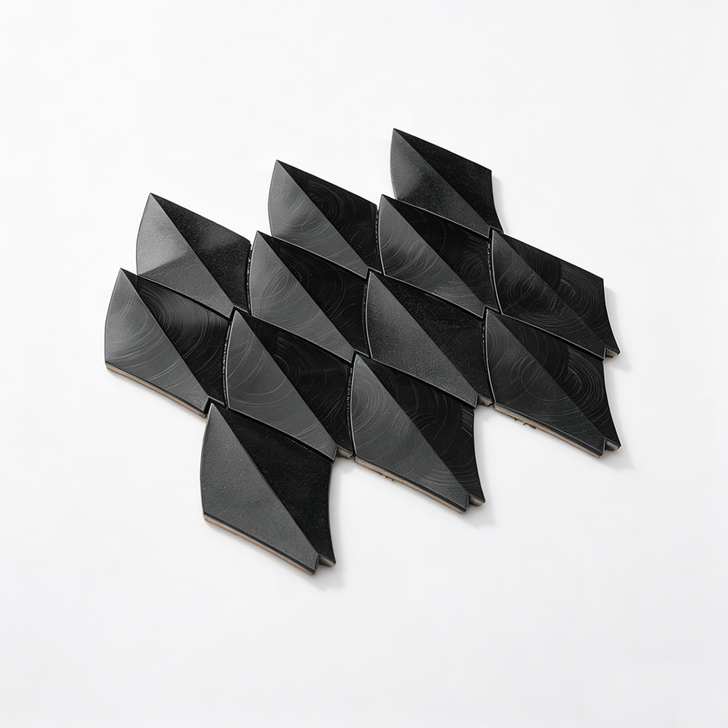 Angled view of black leaf aluminum mosaic tile sheet on a white background