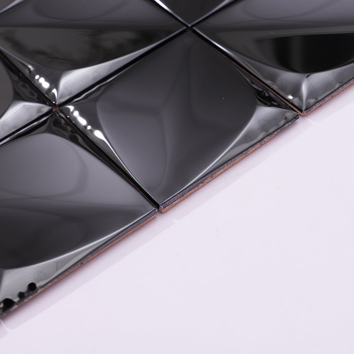 Angled edge view of black mirror 3D metal mosaic tile