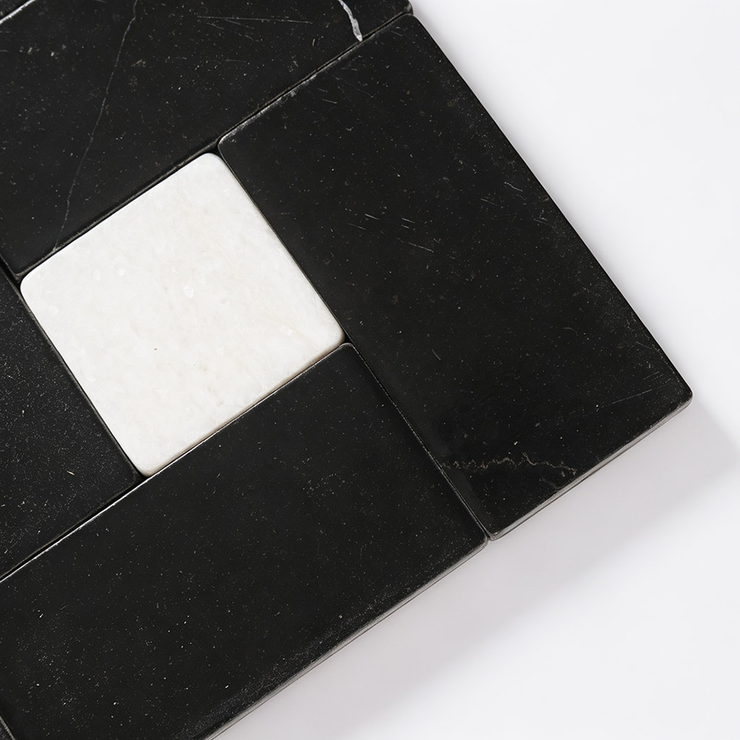 Close-up of white marble square surrounded by black marble rectangles