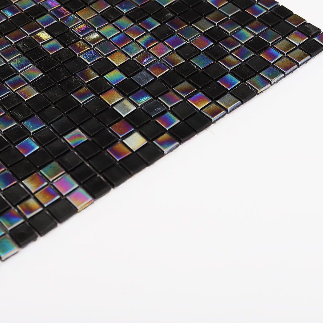 Angled view of black glass mosaic tile surface with colorful reflective pieces