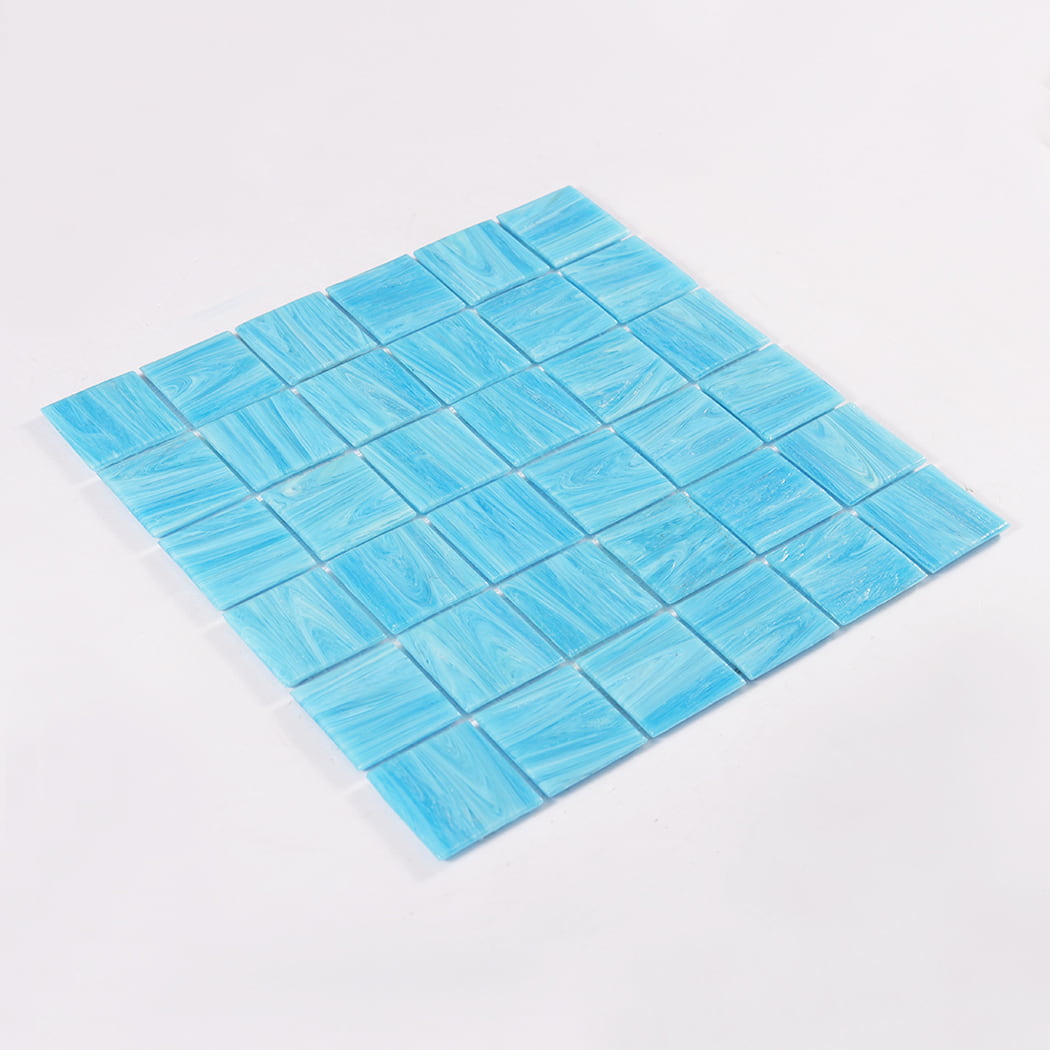 Angled product photo of blue glass mosaic tile sheet on white
