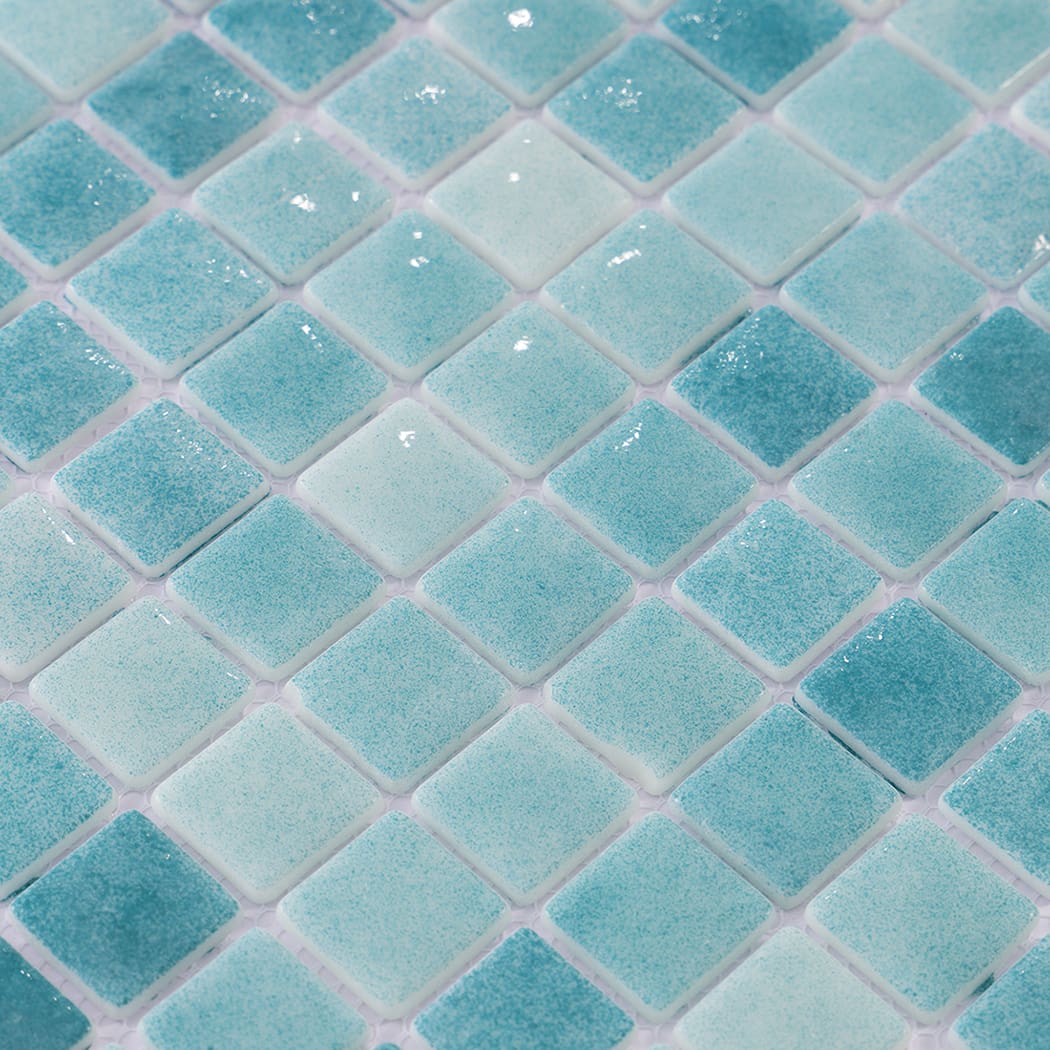 Glossy close-up of blue green recycled glass mosaic tiles.