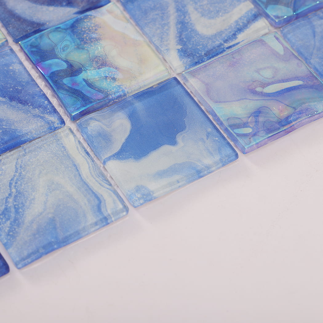 Blue and iridescent square glass mosaic tile surface with glossy waterlike patterns