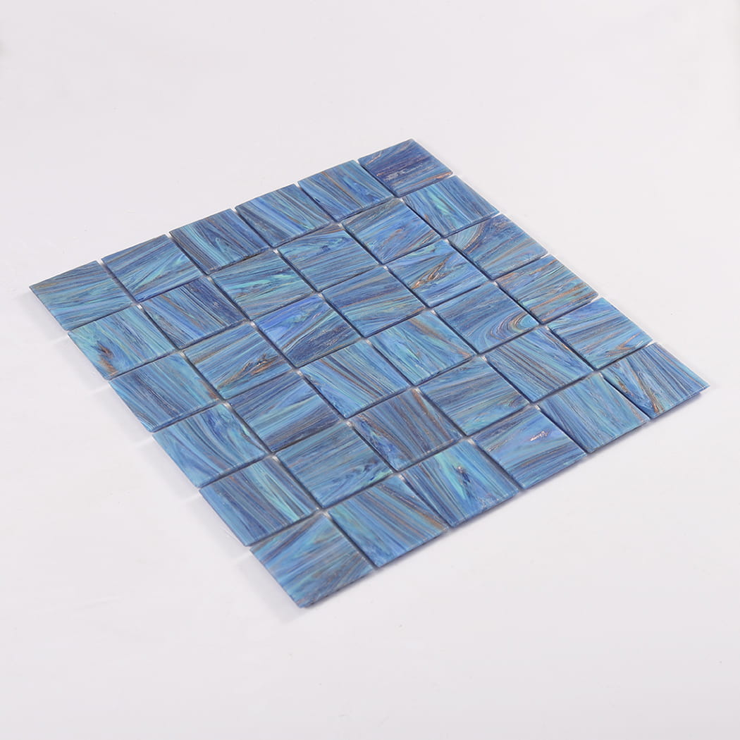 Angled perspective of blue marble glass mosaic sheet laid on a white background