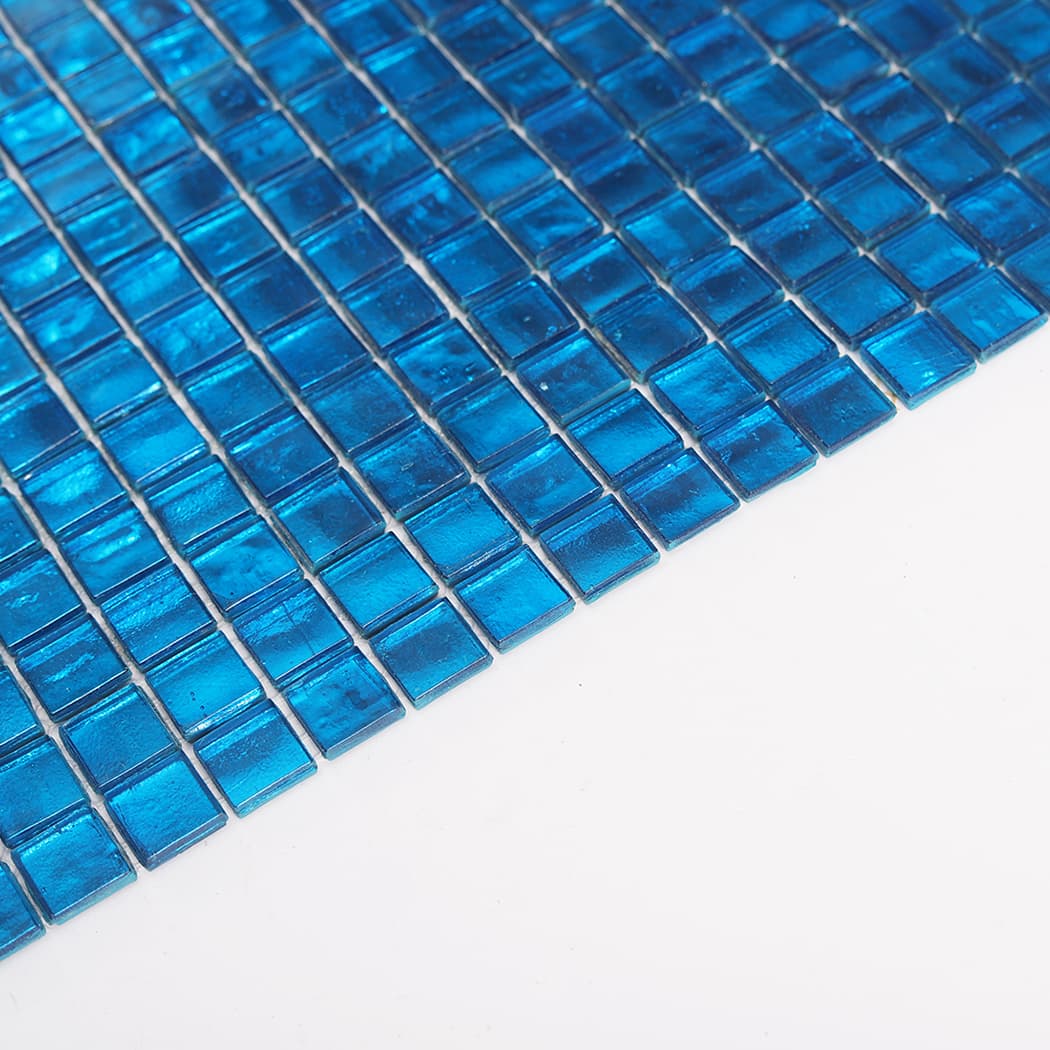Angled view of blue foil glass square mosaic tile sheet highlighting glossy shine