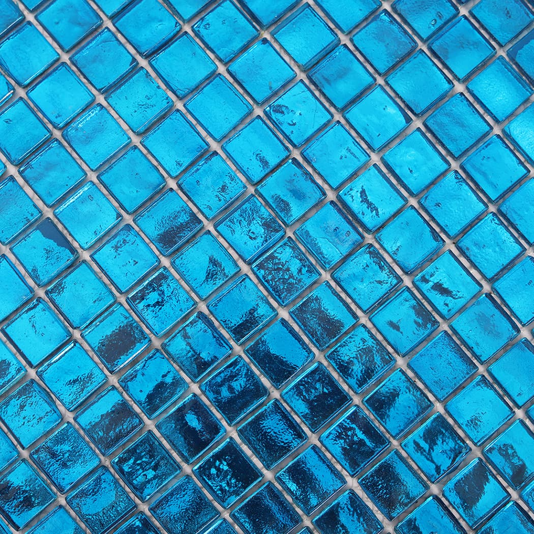 Close up of blue foil glass square mosaic tiles showing foil texture and shine