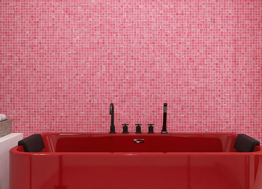 Wide view of a red soaking tub beneath a blush pink glass mosaic tile wall 