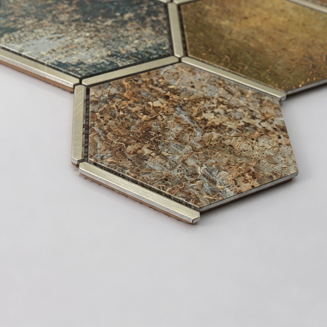 Angled close-up of brown aluminum hexagon mosaic tile with brushed metal trim