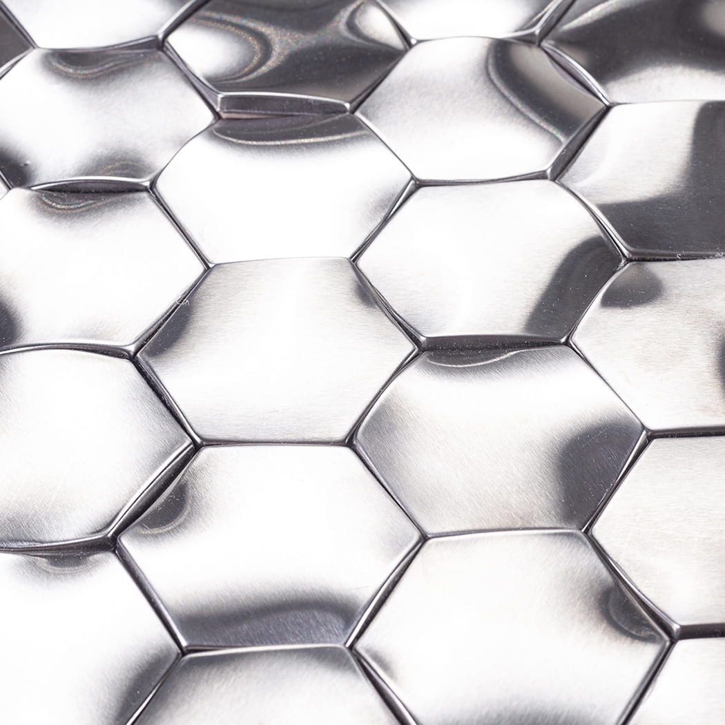 Close-up of brushed texture on silver 3D hexagonal metal mosaic tiles.