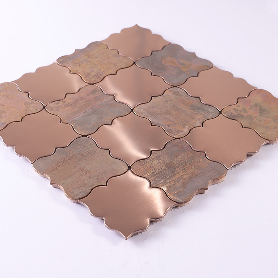Angled view of brushed rose gold and antique bronze arabesque mosaic tile