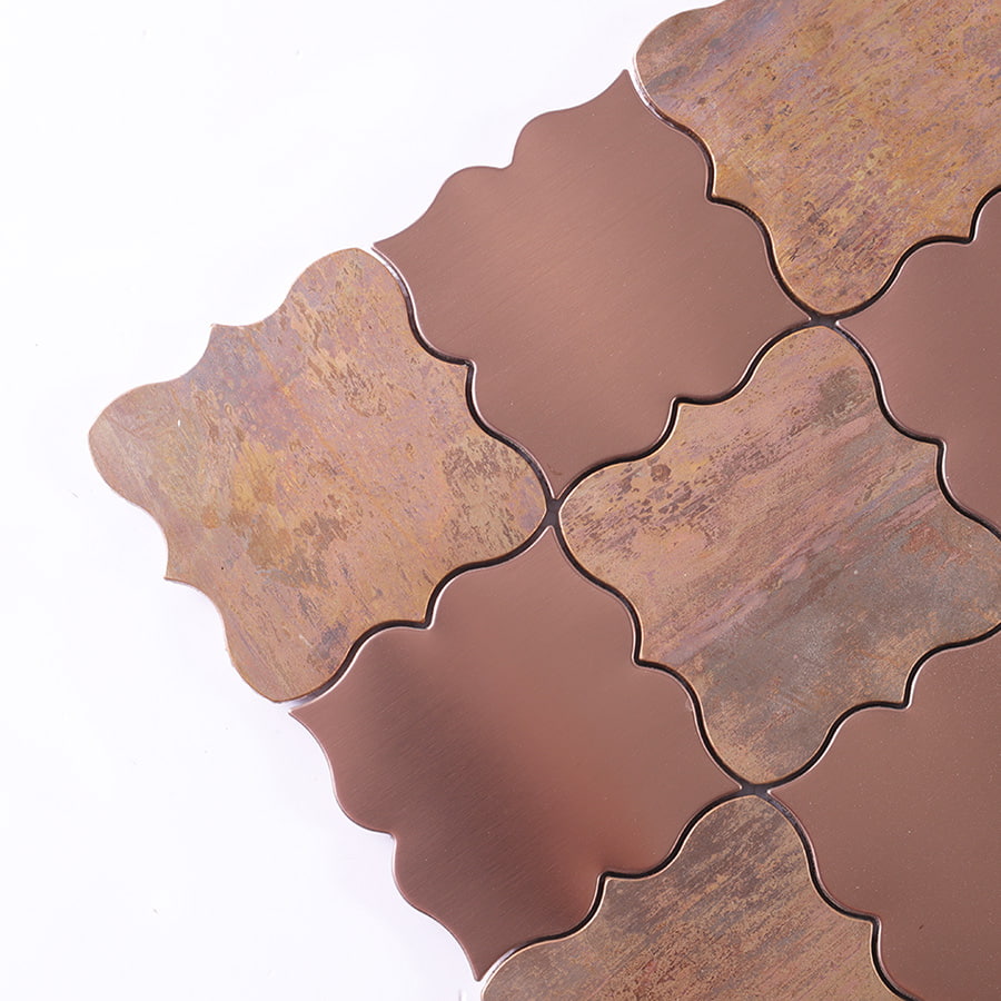 Close up of brushed rose gold and antique bronze arabesque tile corner