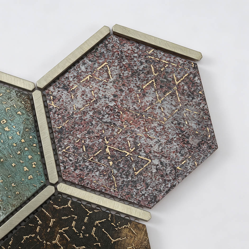 Close-up of burgundy aluminum hexagon mosaic tile with gold texture and metal trim