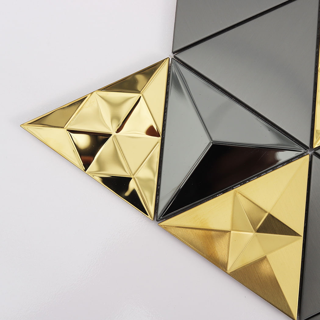 Close-up of faceted gold and matte grey 3D triangle metal tiles.