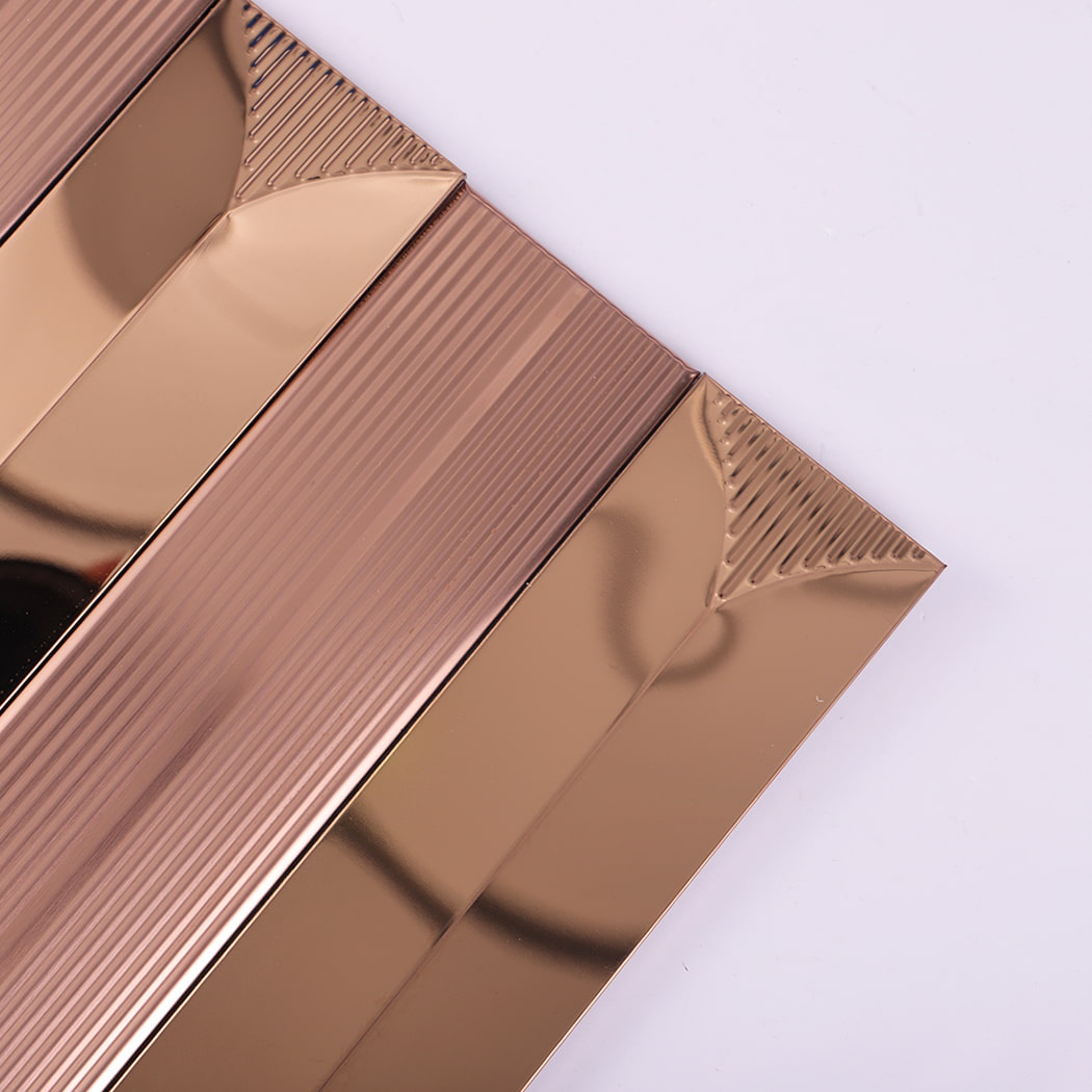 Close-up of rose gold mosaic tile showing decorative textured triangular end details.