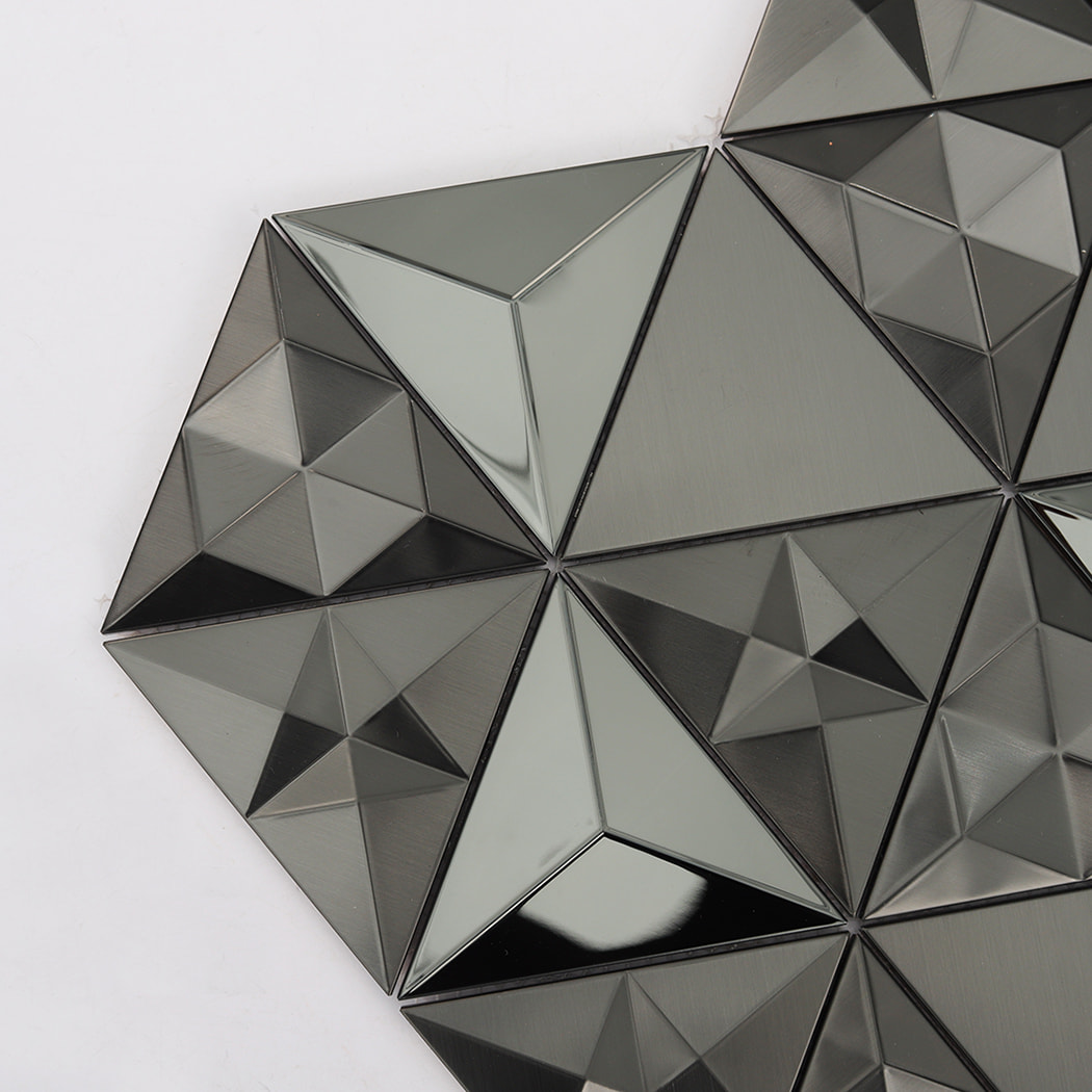 Close-up of black 3D triangle mosaic tiles highlighting faceted and smooth metallic finishes.