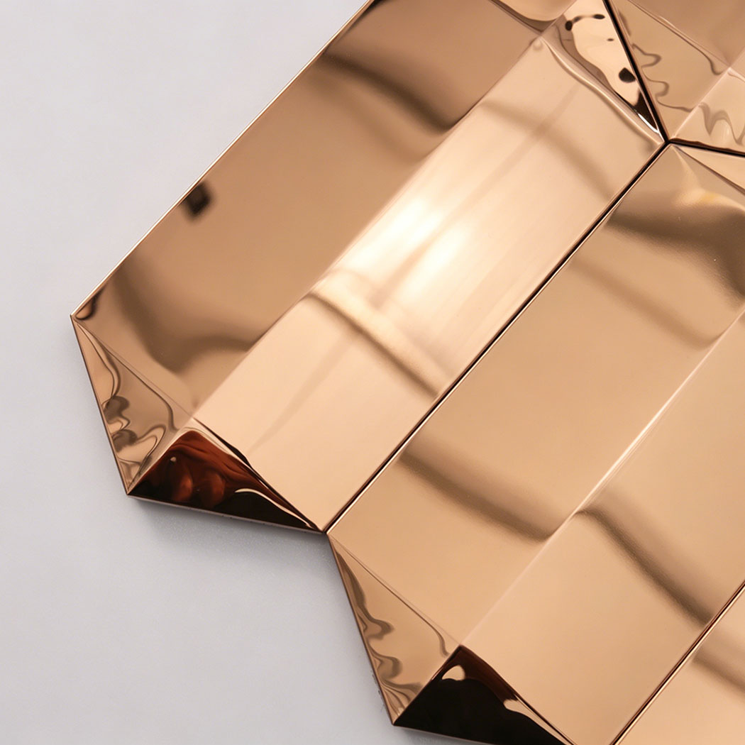 Close up of rose gold mirror picket mosaic tile edge with beveled reflective ends