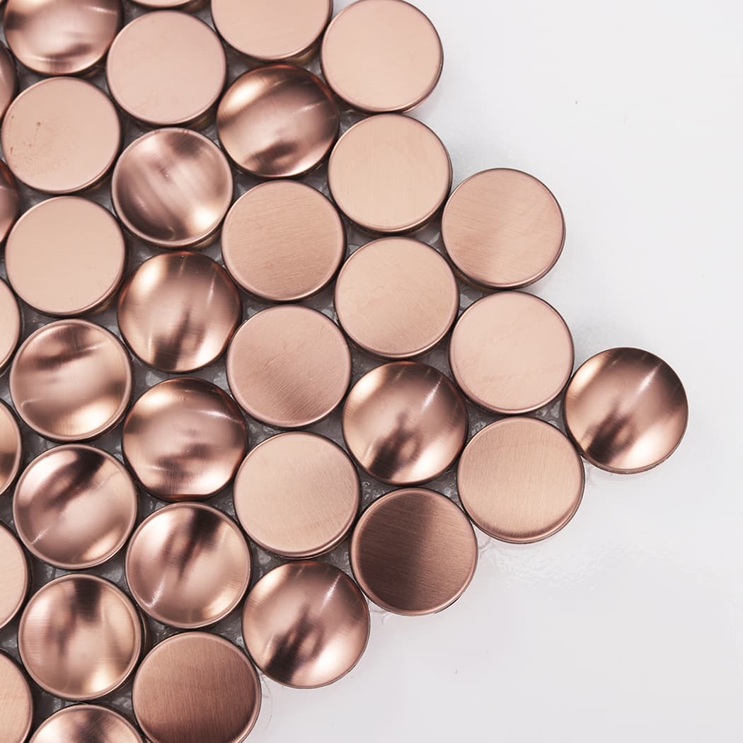 Close-up of mixed profile rose gold penny round tiles showing convex and concave surfaces.