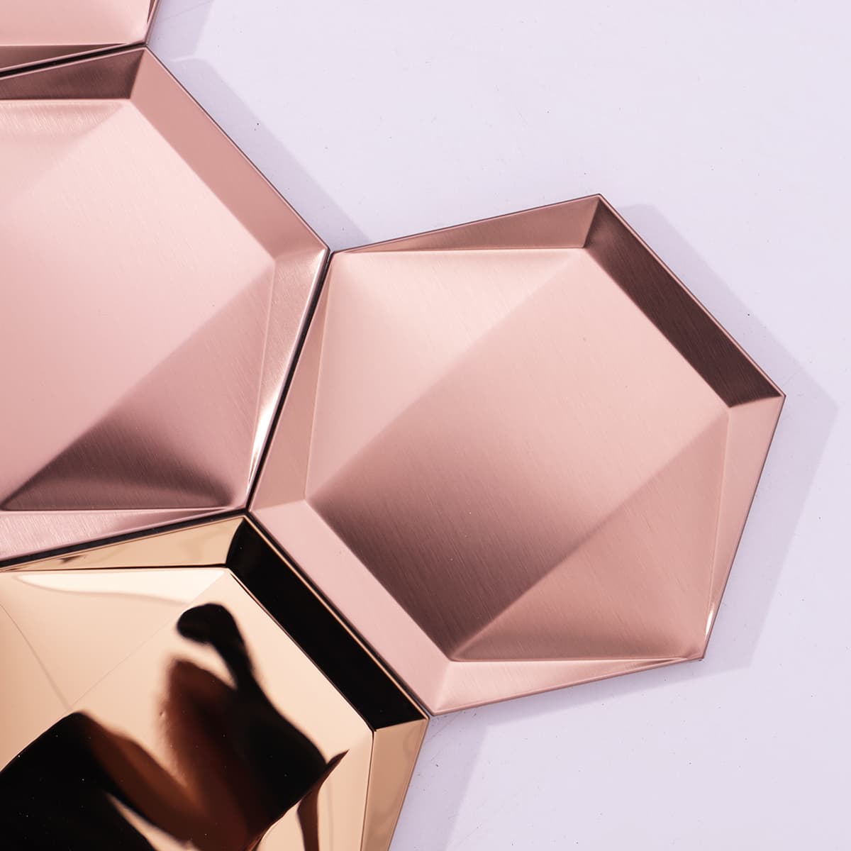 Mixed glossy and matte rose gold finish creates a dynamic wall effect.