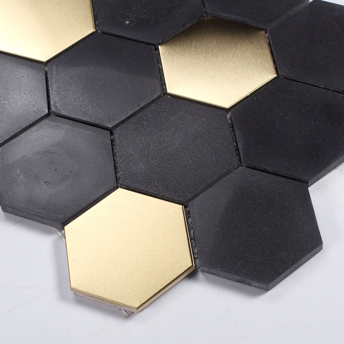 Close-up of black and gold hexagonal mosaic tiles showing their unique pattern
