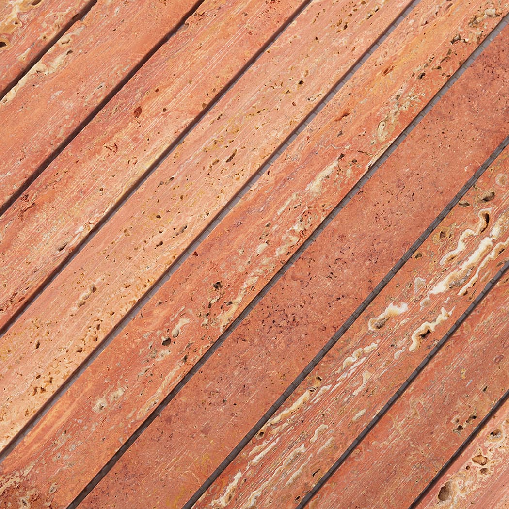 Macro view of the porous surface and rich color variations of Red Travertine tiles.