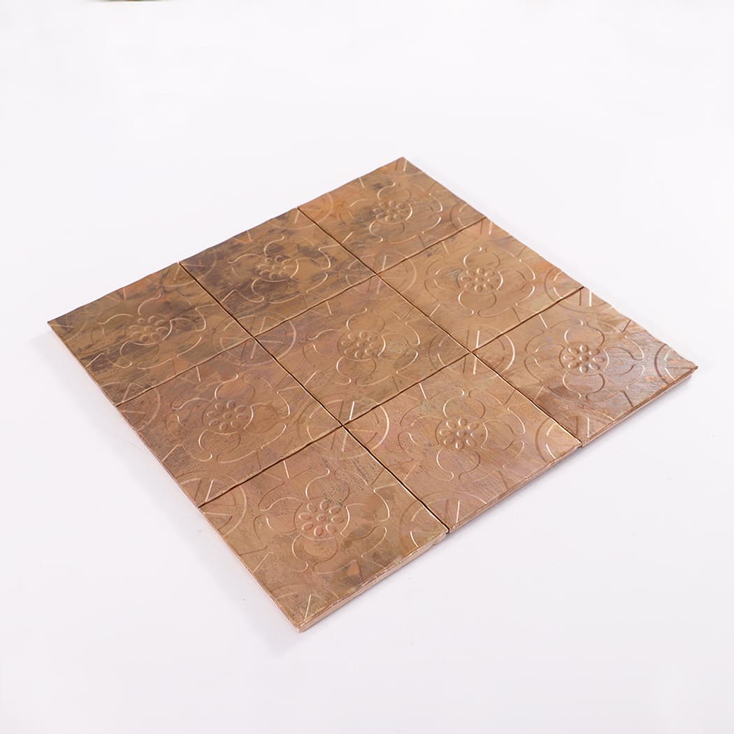 Perspective view of copper embossed flower mosaic tile sheet on white background.