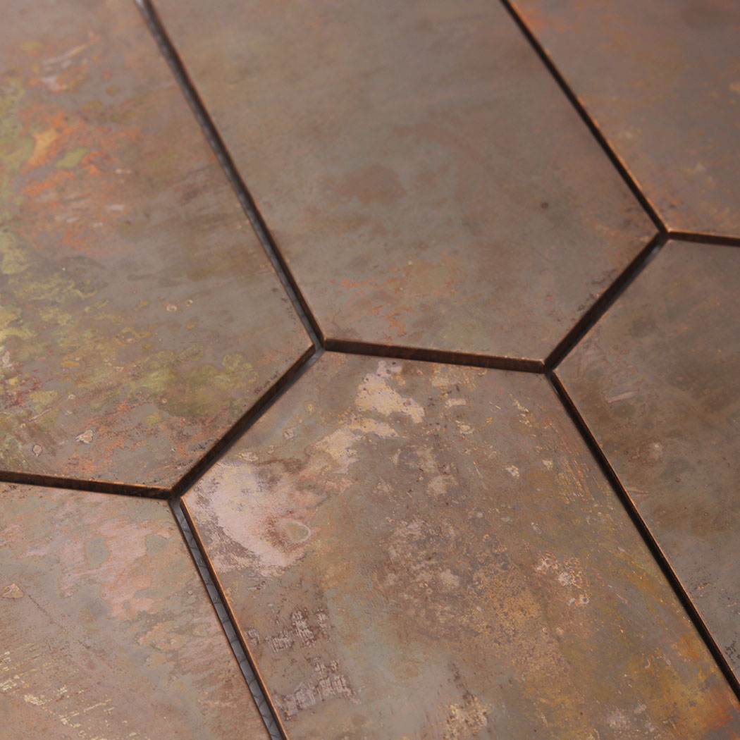 Close up of hexagon mosaic tile edge showing joint and oxidized copper surface