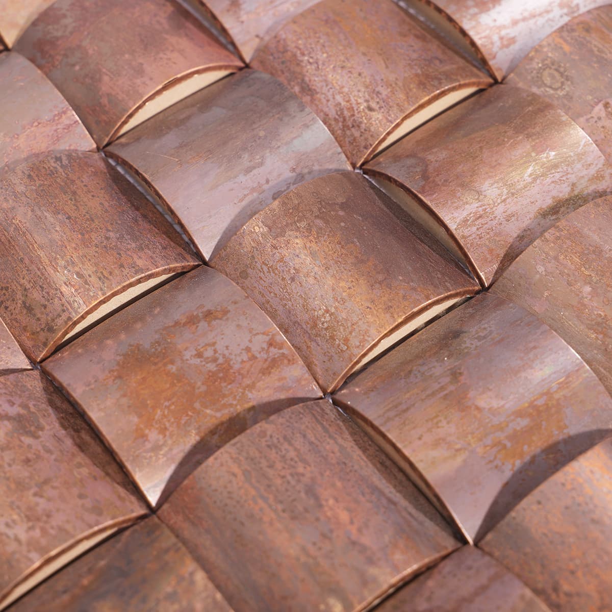 Close-up of the arched, bread-like tile shape with metallic copper finish