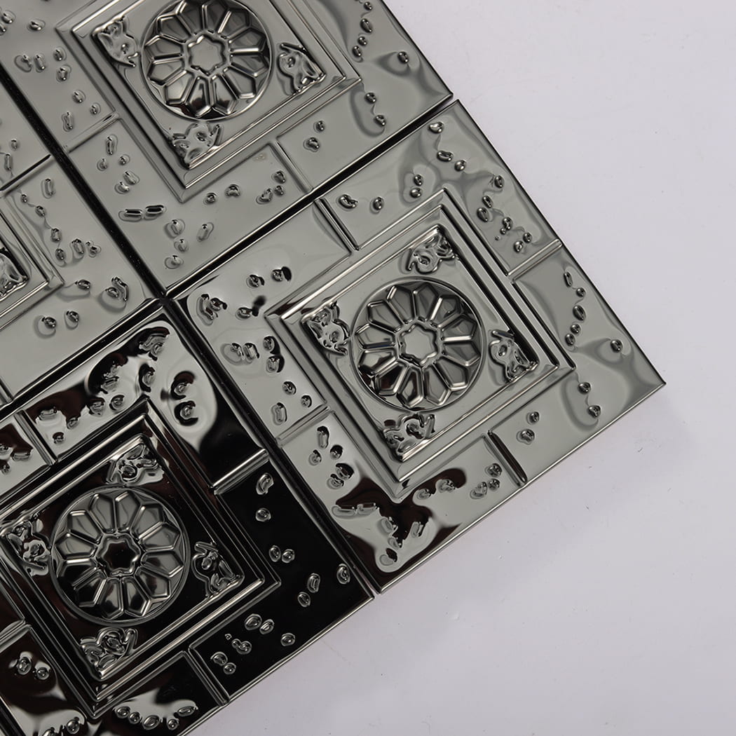 Close up view of glossy black embossed metal mosaic tiles at a corner angle