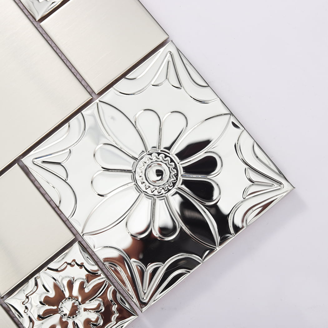 Close up of silver stainless steel tile with embossed flower and reflective surface