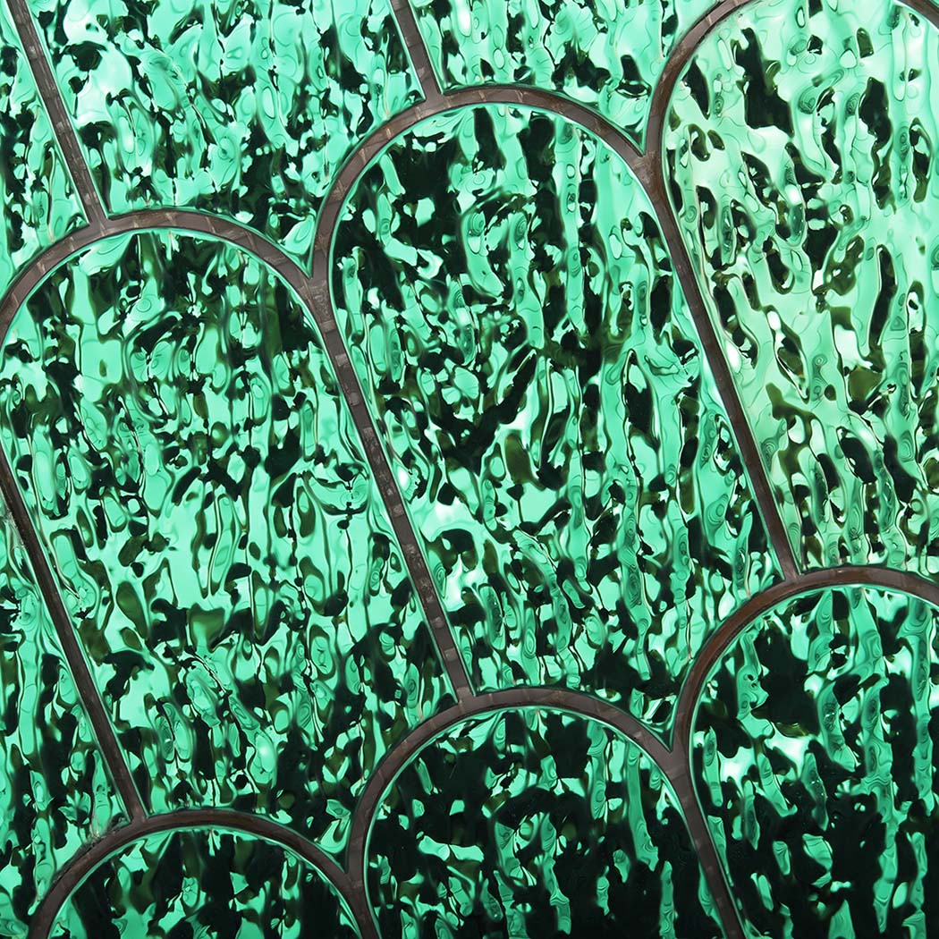 Detailed view of reflective emerald green liquid ripple scallop metal tiles