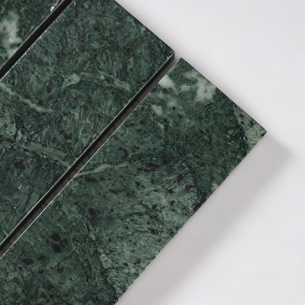 Close-up of forest green marble strip tile showing fine veins and polished finish