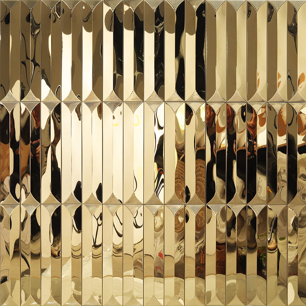 Repeating geometric pattern of gold 3D linear metal mosaic tiles on a full wall.