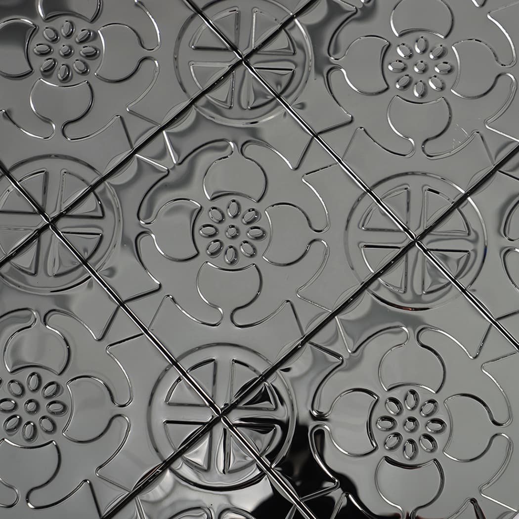 Diagonal close-up highlighting the glossy embossed floral texture on black metal tiles.