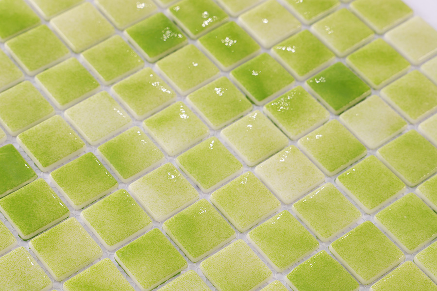 Close-up of glossy green mosaic tiles reflecting light.