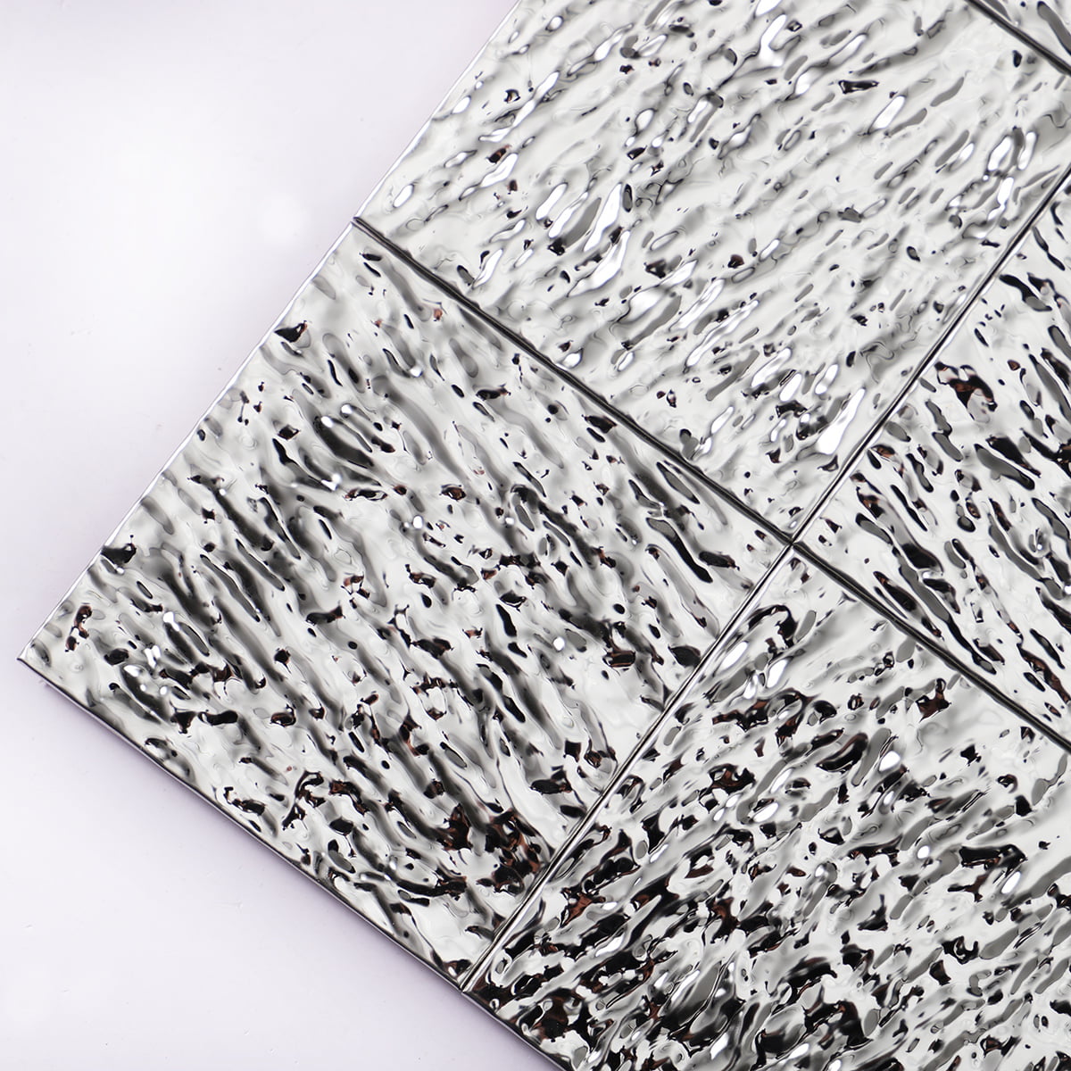Glossy silver ripple-effect tiles with a hammered metal texture and high reflection