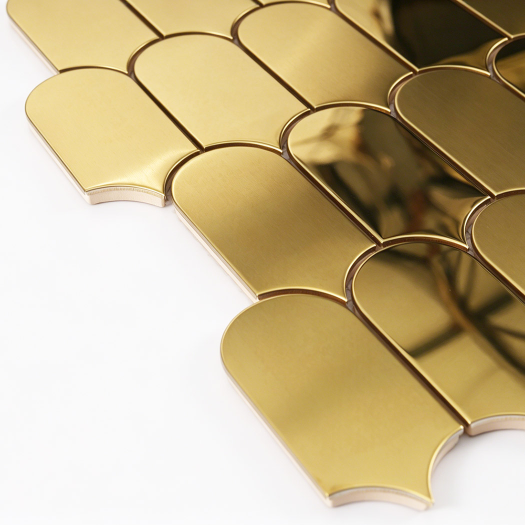 Side close up of gold arch metal mosaic tile showing thickness and curved edges