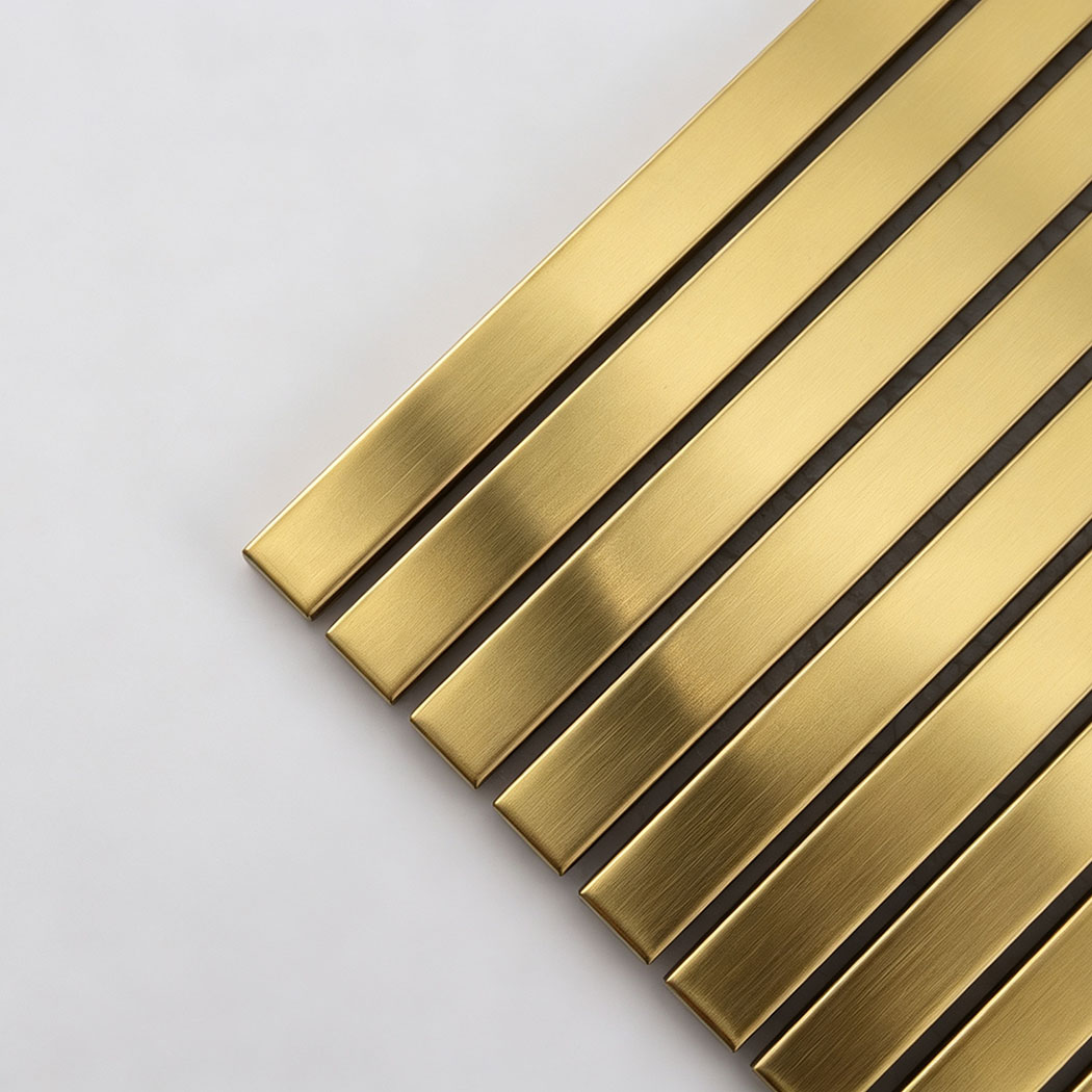 Corner close-up of gold brushed stainless steel linear tile