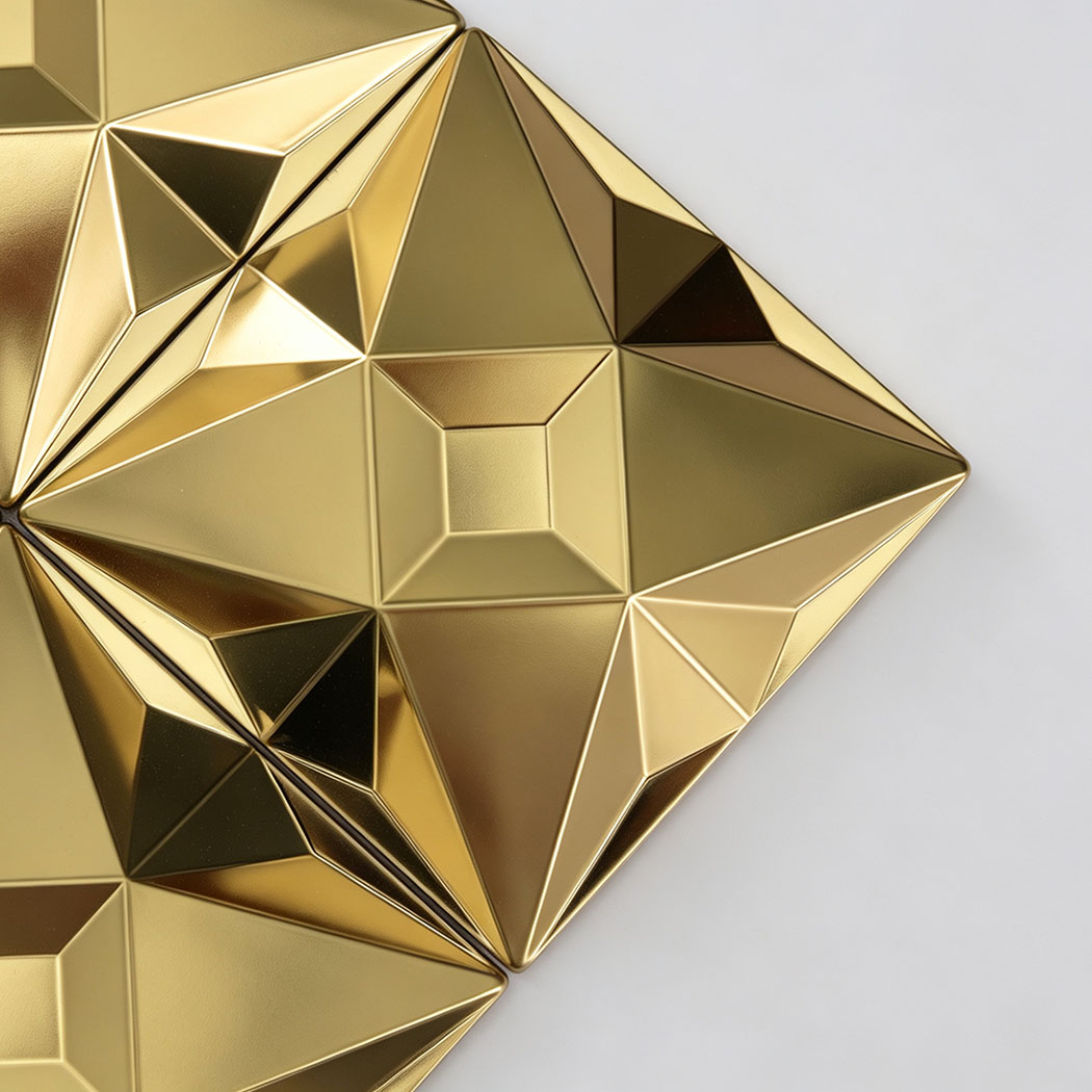 Close up of a gold faceted stainless steel mosaic tile geometric surface