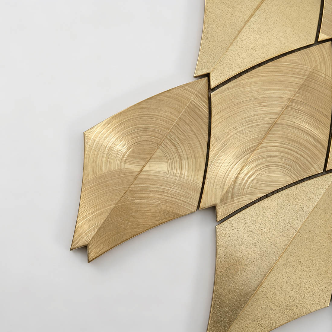 Close-up of gold feather aluminum mosaic tile pattern with brushed and textured finishes