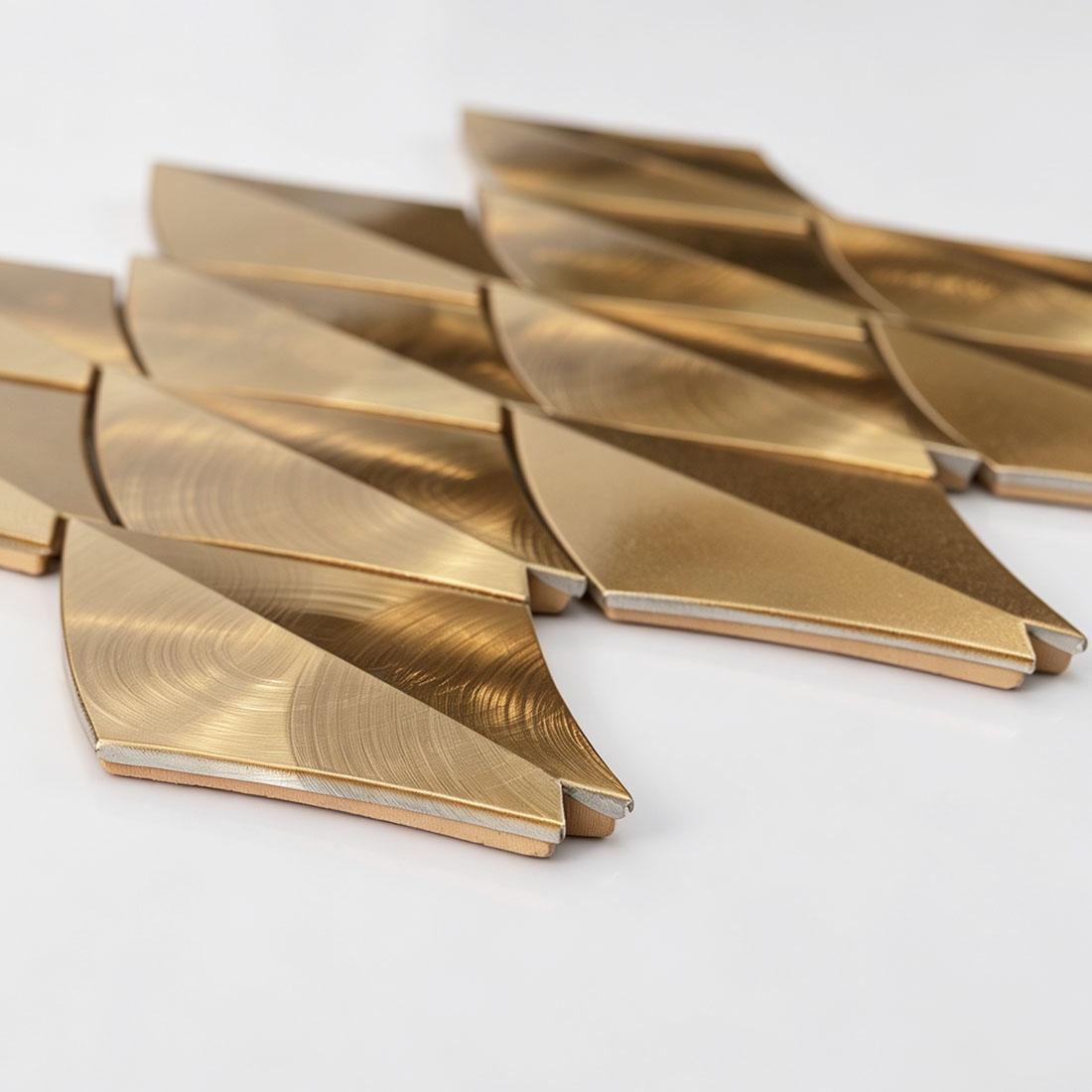 Low-angle view of gold feather aluminum mosaic tiles showing layered construction
