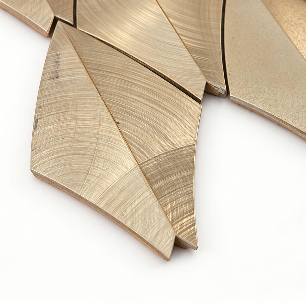 Close-up of gold leaf aluminum mosaic tiles with curved brushed texture
