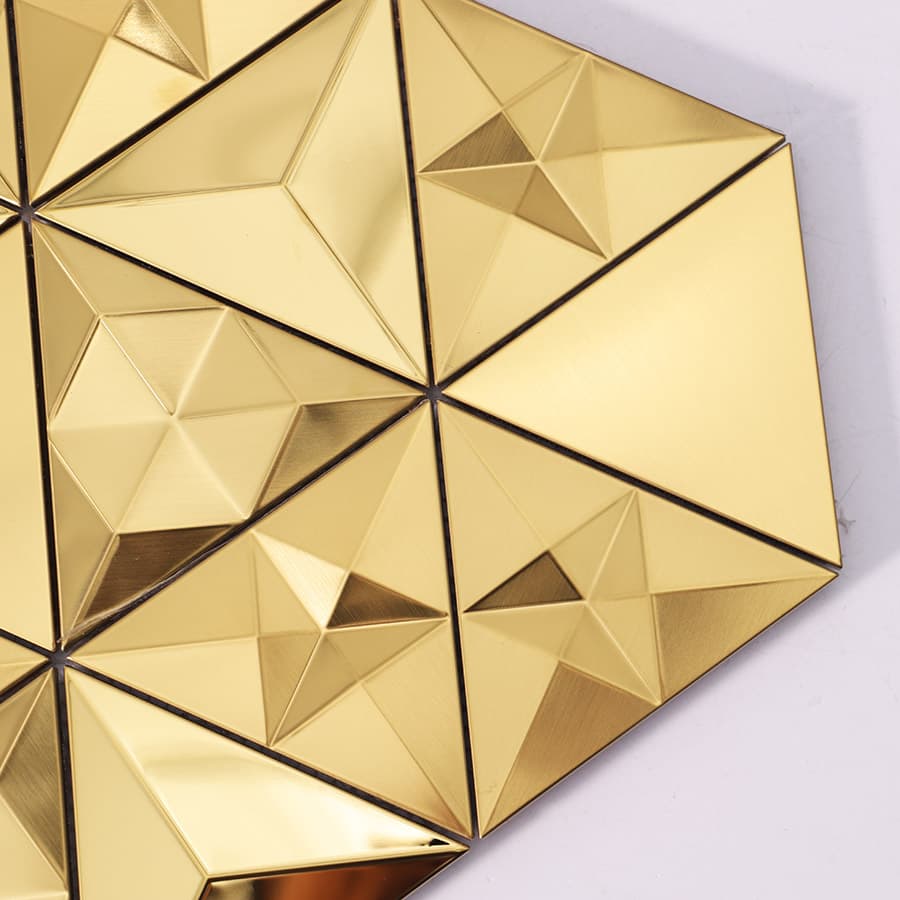Close-up of gold pyramid-style metal mosaic tiles arranged in a geometric pattern.