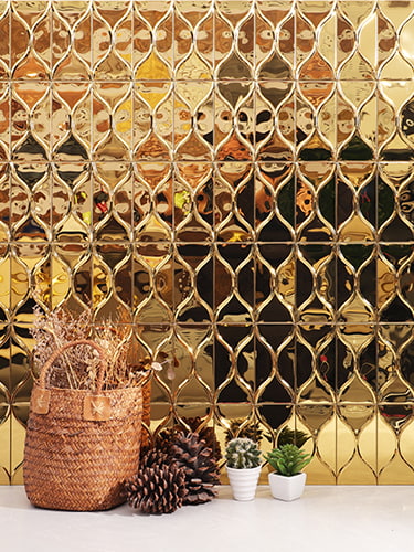 A luxurious gold tile backsplash paired with stylish plants, creating an elegant atmosphere.